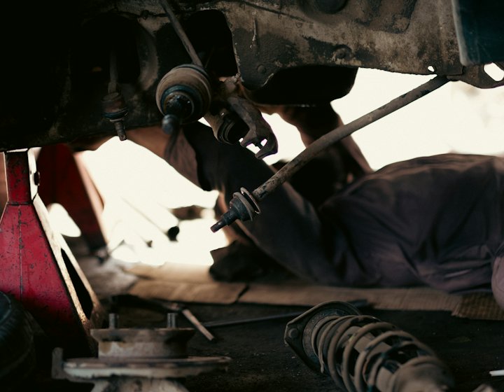 A vehicle being inspected from underneath
